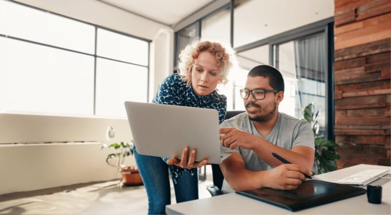 two people holding a laptop