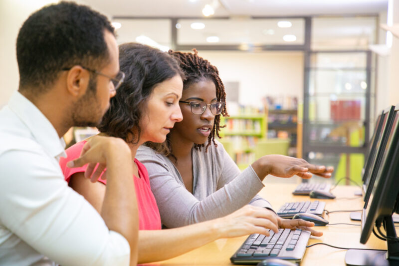 three people over a computer reading