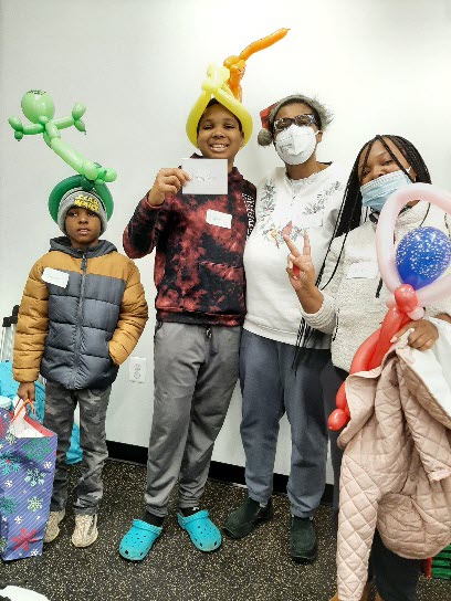 kids and parents with ballon animals posing for a picture